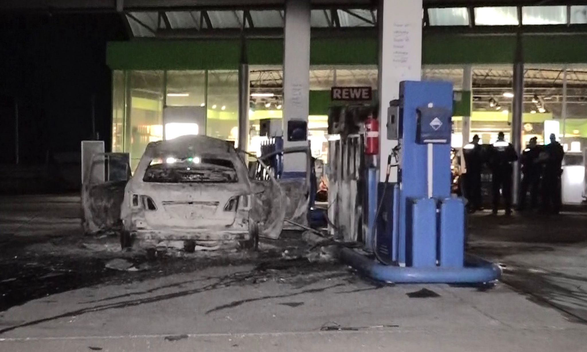 Mann fährt brennendes Auto an Tankstelle und droht mit Axt