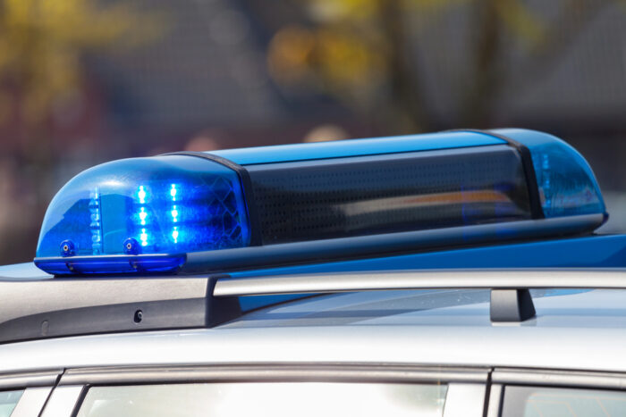 Frau fährt mit Auto in Möbelhaus-Schaufenster